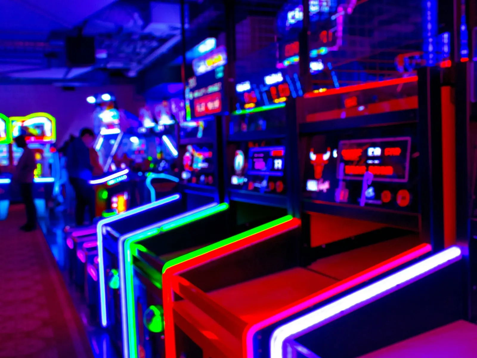 Arcade cabinets glowing under neon light
