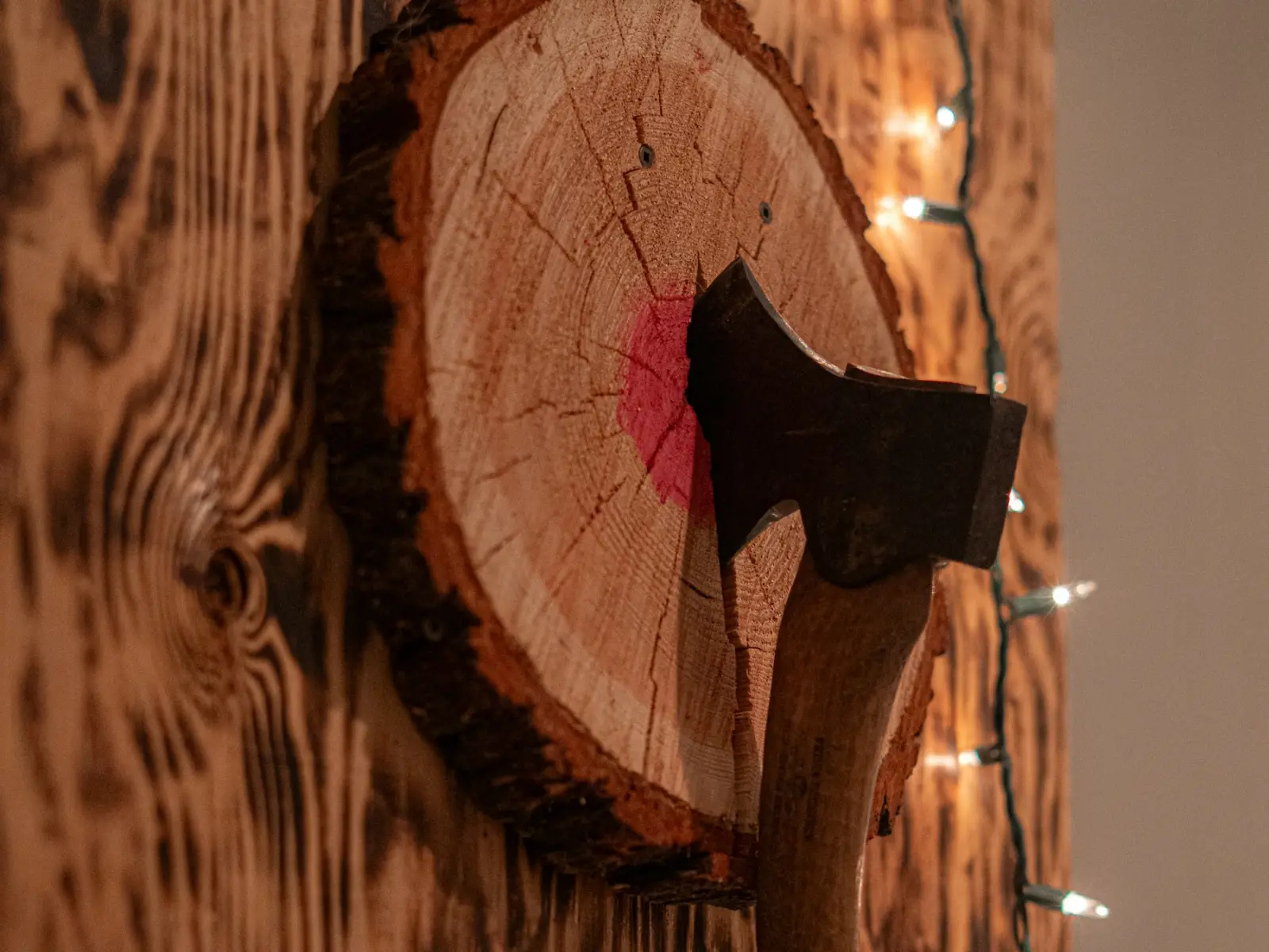 A hatchet stuck in a wooden log target